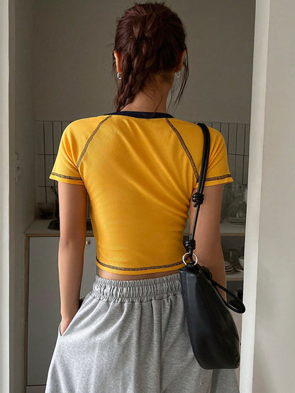 DAZY Camiseta de mujer de manga corta de verano con borde contrastante, diseño de mangas raglán, y estampado de letras amarillas