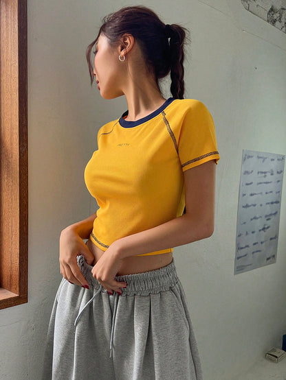 DAZY Camiseta de mujer de manga corta de verano con borde contrastante, diseño de mangas raglán, y estampado de letras amarillas